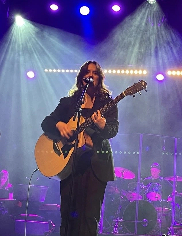 Sånglärare Isa Carlsson på scen med en gitarr